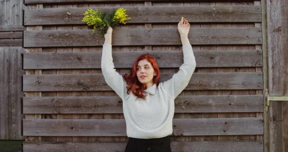 Young Girl with Bunch of Yellow Mimosa Flowers in Her Hand is Having Fun