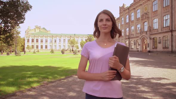 Caucasian Woman with Computer Walks Near University