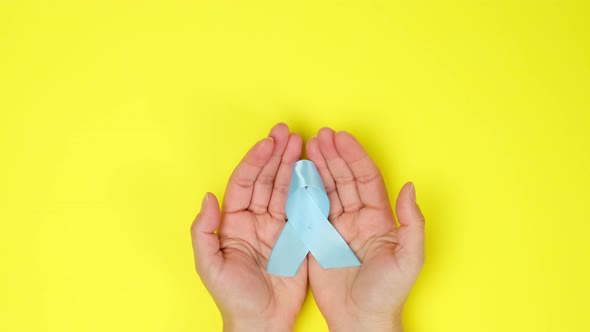 female hand holds blue silk ribbon 