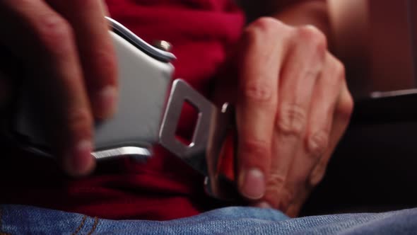 Caucasian Male Hands Passenger of Plane is Uncertainly Trying to Fasten Seat Belt in Closeup