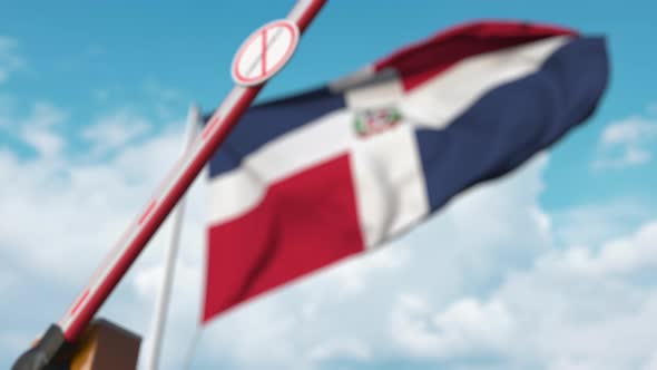 Closed Gate with STOP CORONAVIRUS Sign Near the Dominican Flag alt
