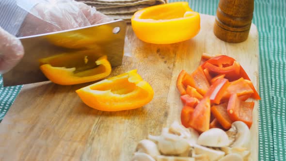 The Chef Cuts the Yellow and Sweet Peppers with a Professional Knife