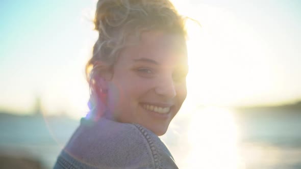 Closeup Slow Motion of Beautiful Girl with Fair Hair and Blue Eyes Standing Near Sea Turning at