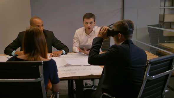 Confident Entrepreneur in Virtual Reality Glasses. Group of Young Developers Working on Building and