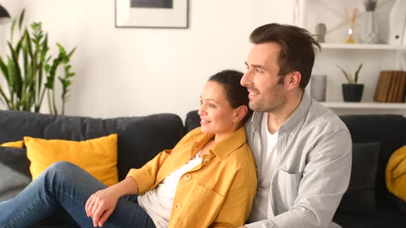 Gentle and Lovely Midaged Couple in Love Sitting in Embrace on the Comfortable Sofa