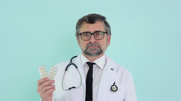 Senior Doctor Pharmacist Consultant Showing a Two Packs of Pills and Smiling in Camera