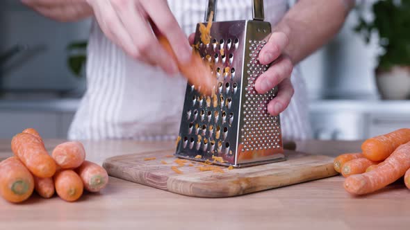 Male Hands Grating Carrots on Cutting Board. - Slider Right