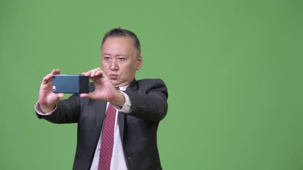 Mature Japanese Businessman Using Phone