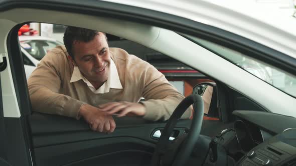 An Adult Man Enjoys the Interior of a Car