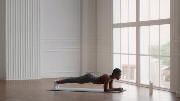 Athletic Young Black Woman Making Plank Exercise While Training At Home