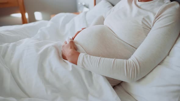 African pregnant woman stroking her belly