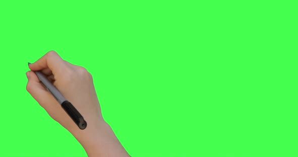 Female hand holding pen and nullifies or crosses out something. Green screen background. 