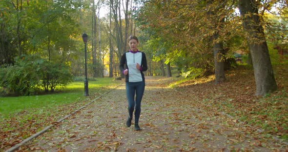 Woman Running in the Sunny City Park. Morning Light