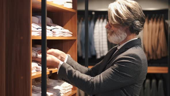 Man Chossing Clothes at Men's Wear Store