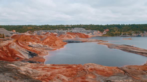 Orange Clay Cliffs and Lake - Forest in the Distance