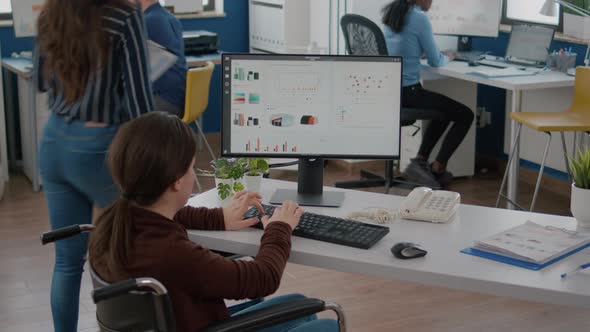 Handicapped Businesswoman Analysing Financial Statistics Sitting in Wheelchair