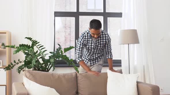 Indian Man Arranging Sofa Cushions at Home 46