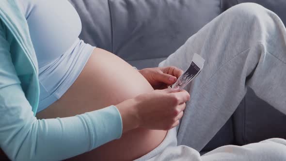 Young pregnant woman is resting at home and expecting a baby.