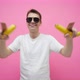 The guy with bananas is dancing in sunglasses on a pink background. - VideoHive Item for Sale