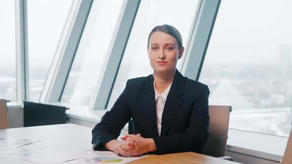 Young businesswoman looking at camera consult client from computer