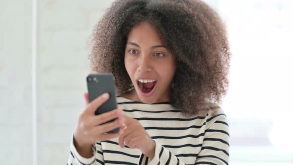 Excited Woman Celebrating Success on Smartphone 