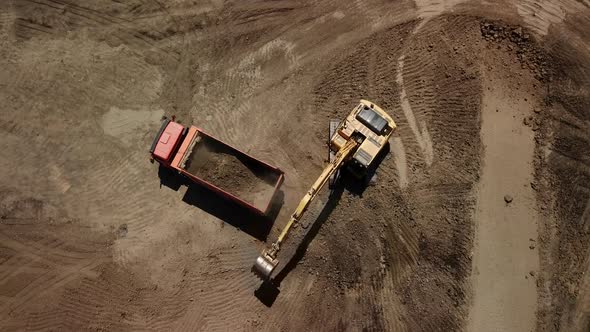 Aerial View of Excavator Pours Sand Into the Truck