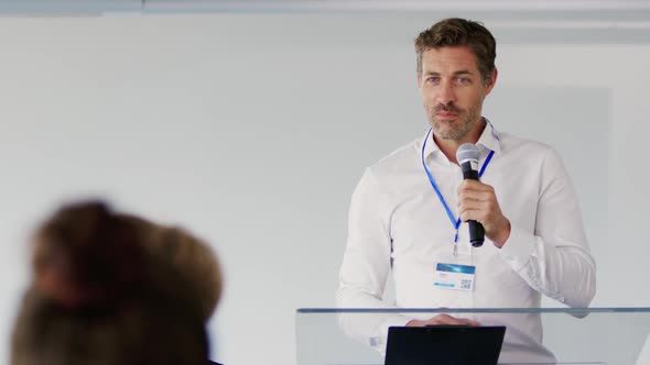 Male speaker addressing the audience at a business conference