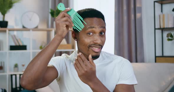 African American which Combing His Hair with Special Comb and Looking Into Camera