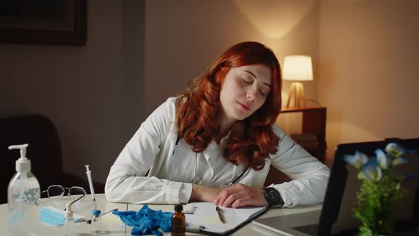 Young Female Doctor Sleeps on the Hospital Desk Tired of the Shift