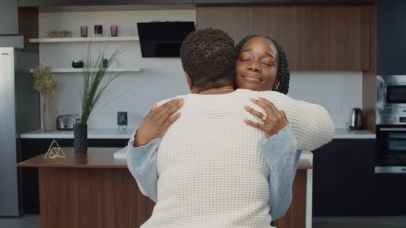 Affectionate Black Teenage Girl Hugging Mom Indoors