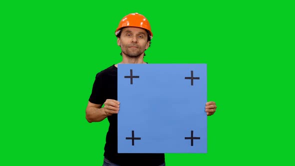 Builder In Hardhat Holding Blank Mockup Board on Green Screen 