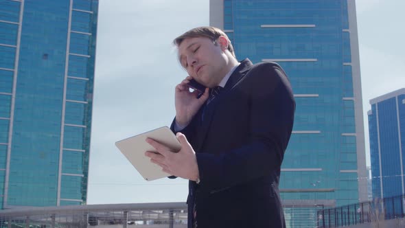 Businessman working in front of luxury buildings.