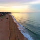 Flying along a sandy beach over the edge of the calm sea in the evening against the orange 4K 30fps - VideoHive Item for Sale