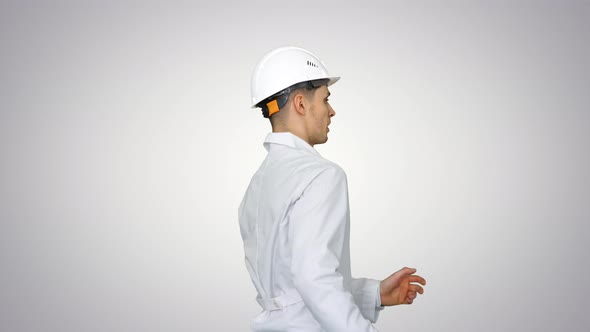 Young Workman with Helmet in White Robe Enjoy Dancing on Gradient Background.