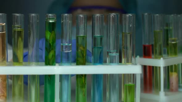 Laboratory Worker Dripping Oily Substance Into Test Tube With Red Liquid Sample