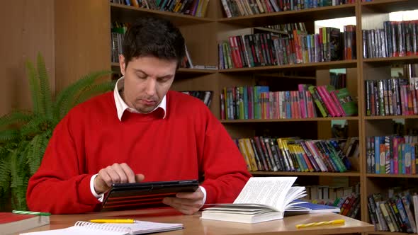 Student Using His Digital Tablet in a Library