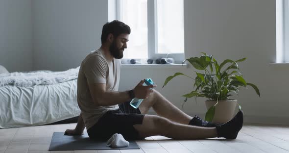 Tired Guy Drinking Water, Taking Break in Workout