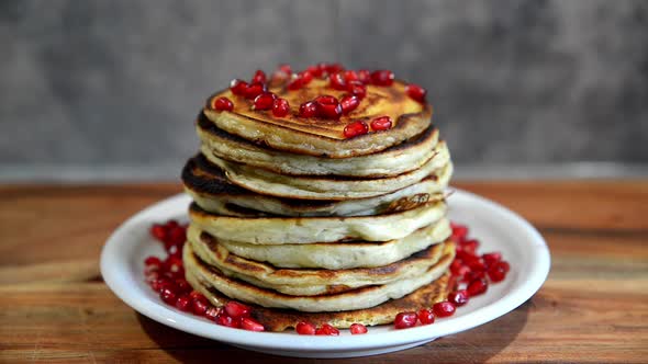 Pile of pancakes with maple sirup and berries.