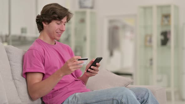 Casual Young Man Making Online Payment on Smartphone 