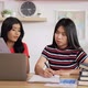 Portrait of Two Asian schoolgirl studying online making notes in copybook - VideoHive Item for Sale