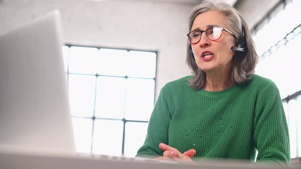 Mature Senior Woman is Using a Laptop for Video Call at Home