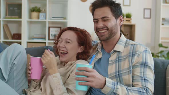Couple Laughing Hysterically Watching TV