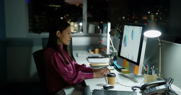 Side view of young Caucasian female executive working on computer at desk in a modern office 4k