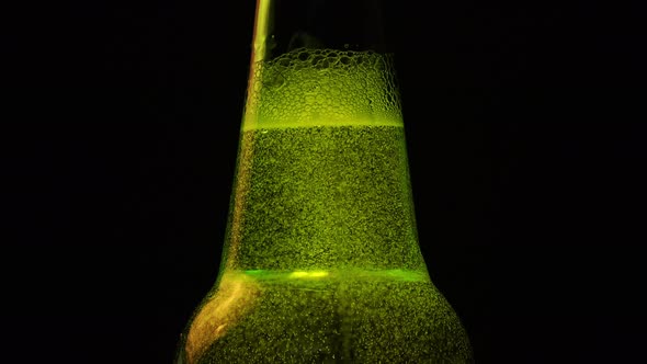 A Green Bottle neck with a lot of bubbles is on black background