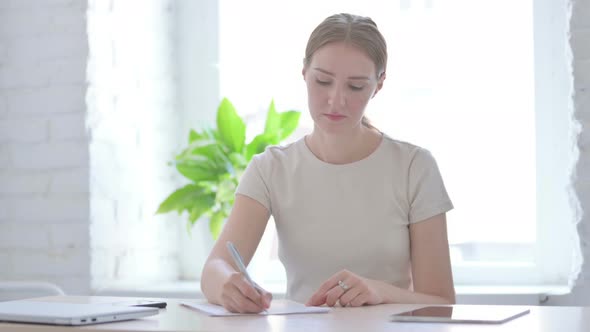 Woman Writing on Paper in Office