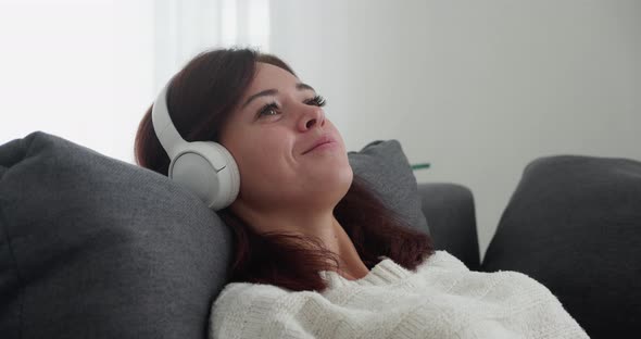 Smiling Woman Listening to Music on Headphones