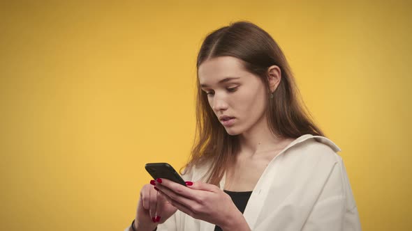 Young Adult Caucasian Woman Recieving Good News on a Bright Yellow Background