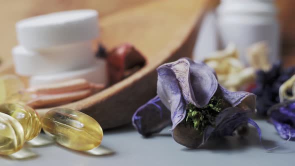 Tablets and capsules in a wooden spoon. Multivitamins and supplements natural product concept.