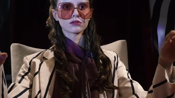 Psychiatrist Doctor Leads a Patient Girl in Stylish Striped Suit Sits Chair Against Hypnotic Spiral