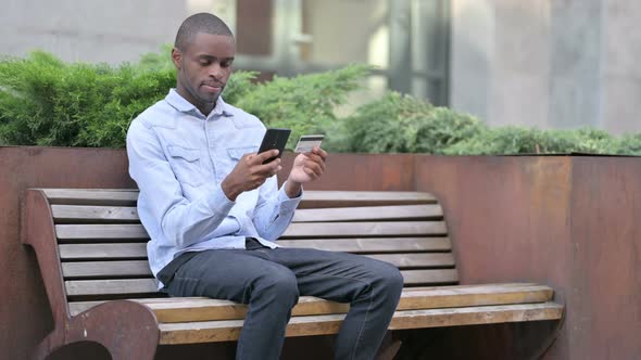 African Man Making Successful Online Payment on Smartphone 